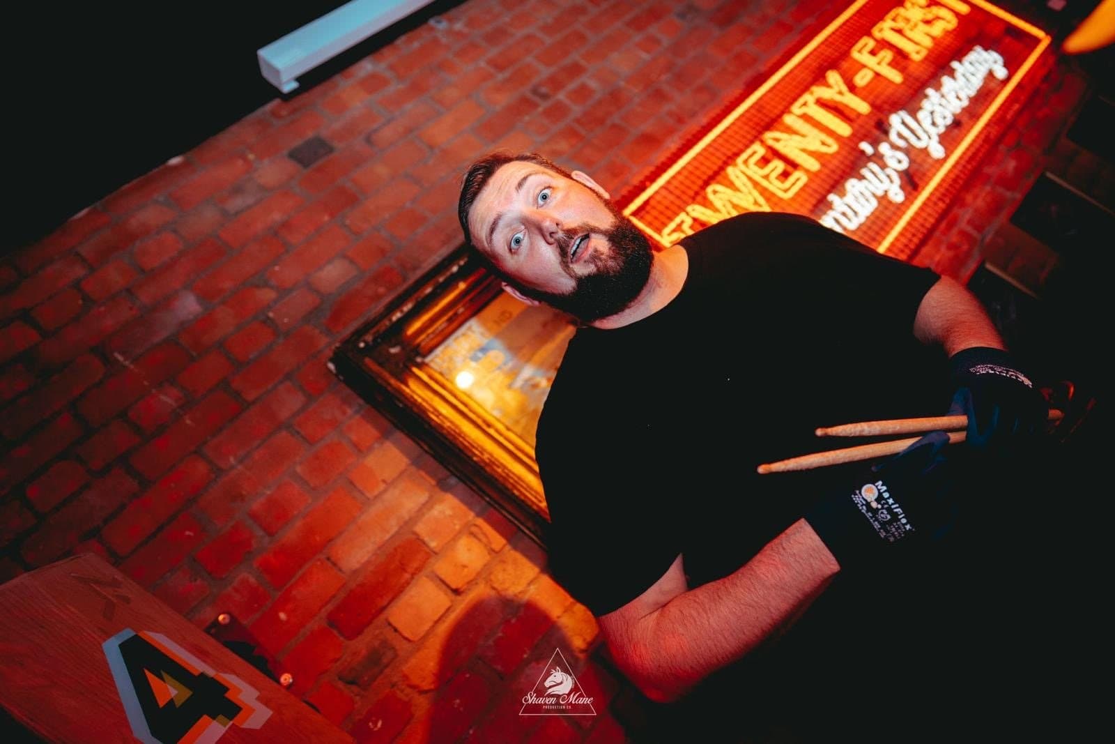 A drummer with sticks raised mid-set.