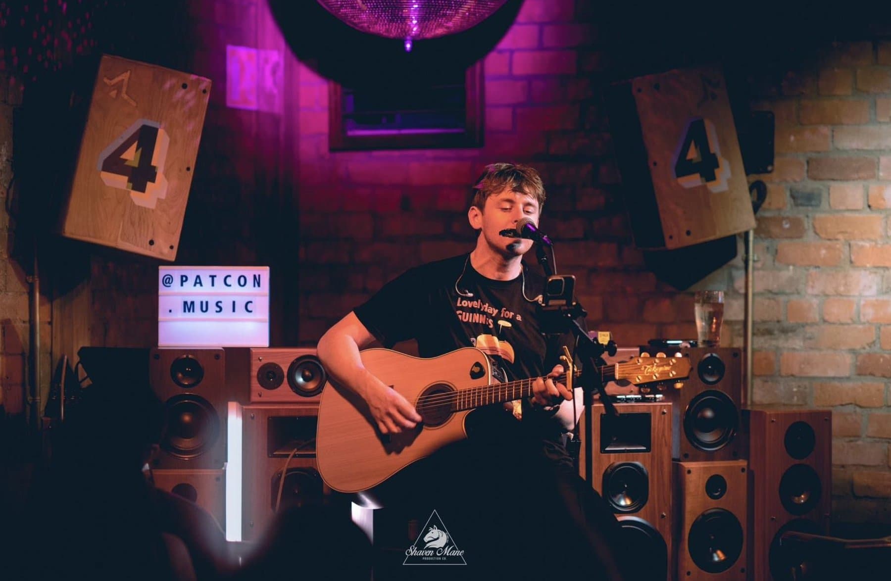 A solo acoustic act set up beside the speakers.